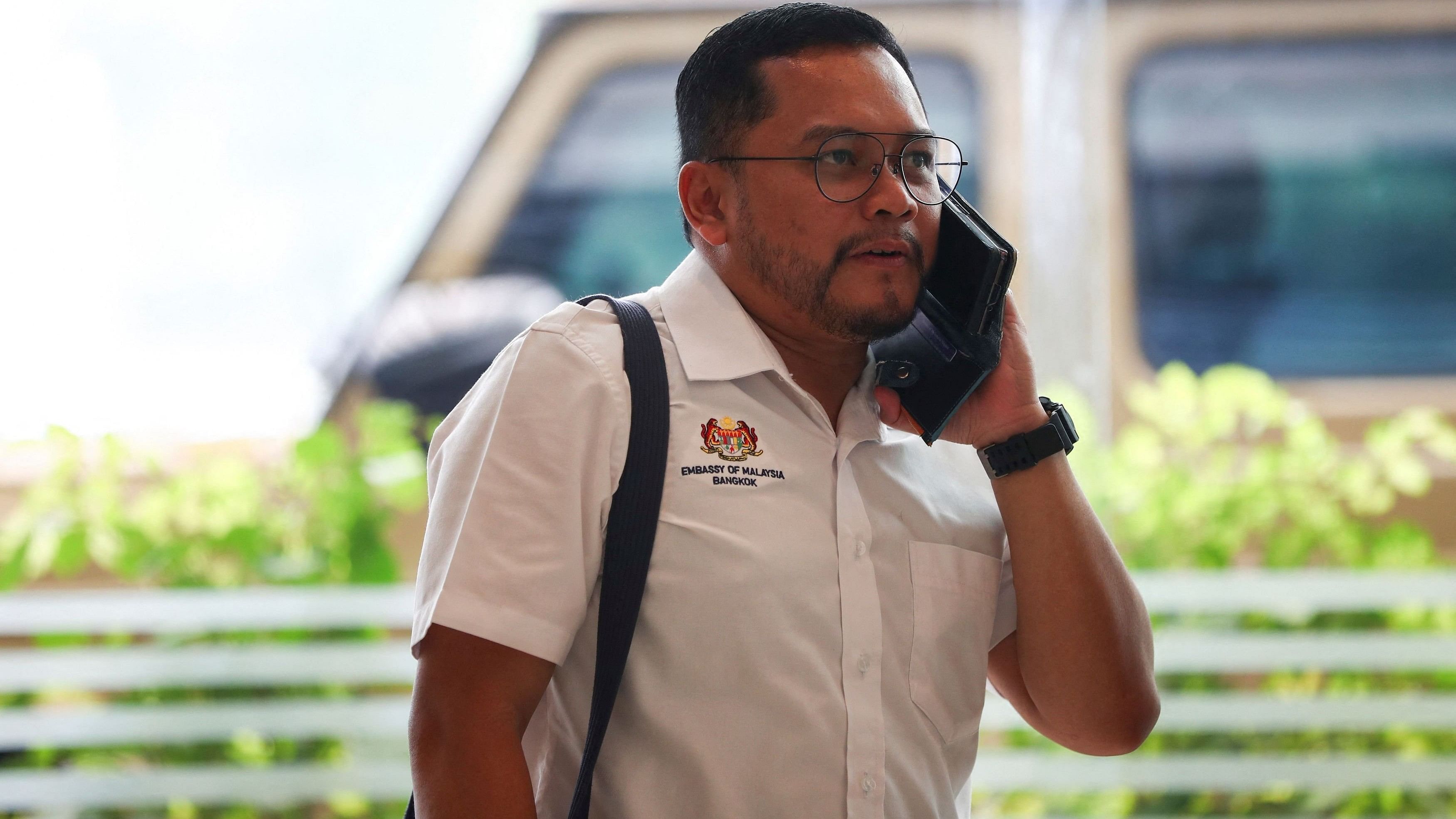 <div class="paragraphs"><p>A representative of the Malaysian embassy talks on the phone as he visits the Samitivej Hospital where injured passengers and crew of Singapore Airlines flight SQ321 have been transferred following an emergency landing, in Bangkok Thailand, May 22, 2024.</p></div>