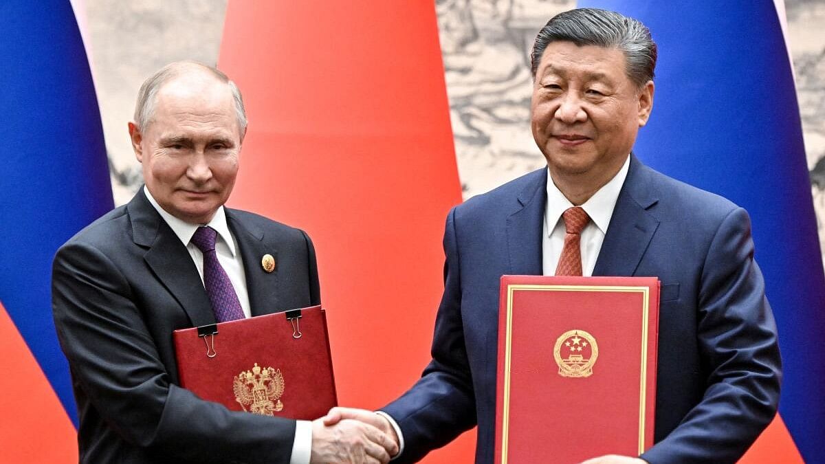 <div class="paragraphs"><p>Russian President Vladimir Putin (left) and his Chinese counterpart Xi Jinping exchange bilateral documents during a meeting in Beijing.&nbsp;</p></div>