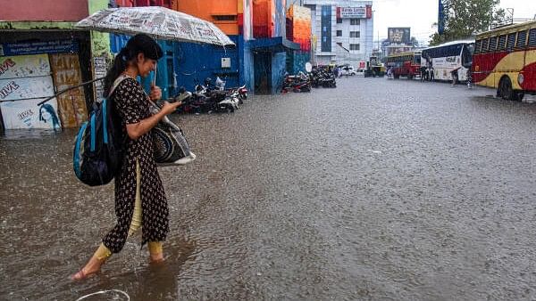 <div class="paragraphs"><p>A commuter at a waterlogged Kerala State Road Transport Corporation (KSRTC) station amid heavy rain, in Kochi.</p></div>