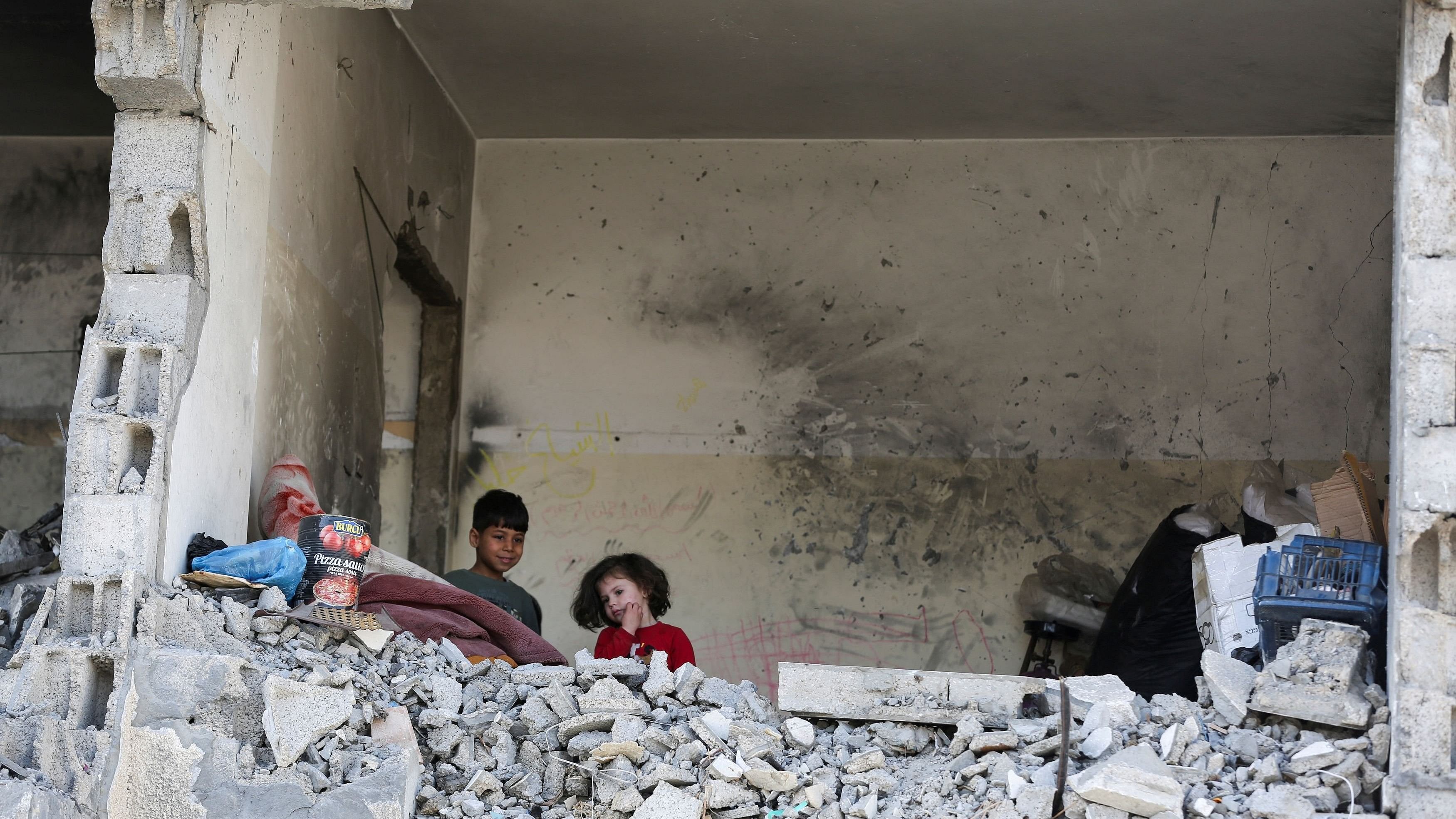 <div class="paragraphs"><p>Palestinian kids stand in a house destroyed by an Israeli strike, amid the ongoing conflict between Israel and the Palestinian&nbsp; group Hamas, in Rafah, southern Gaza Strip.</p></div>