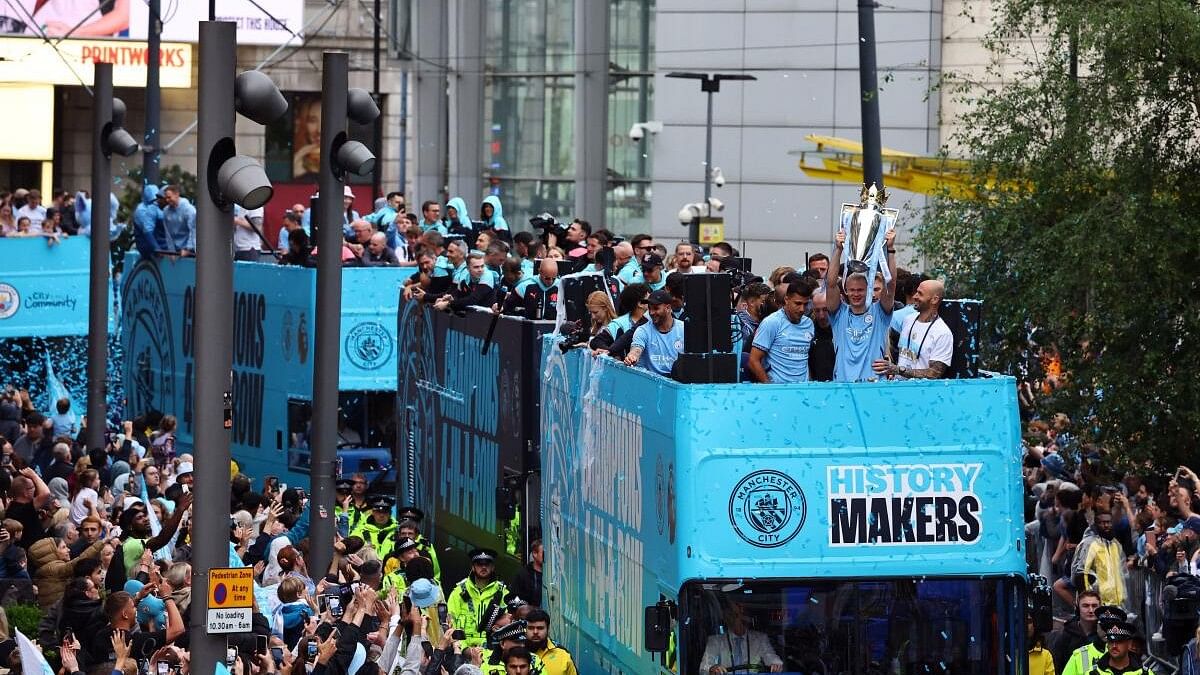 <div class="paragraphs"><p>Manchester City's players celebrate with the Premier League trophy on the bus during the victory parade.</p></div>