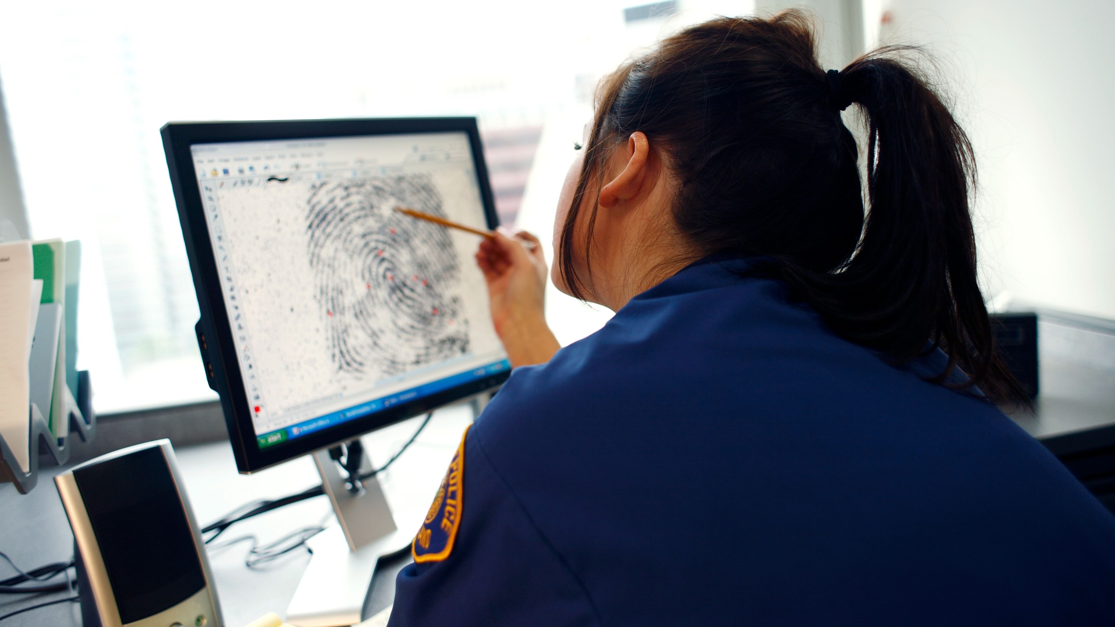 <div class="paragraphs"><p>A young officer viewing a fingerprint on a computer.</p><p></p></div>
