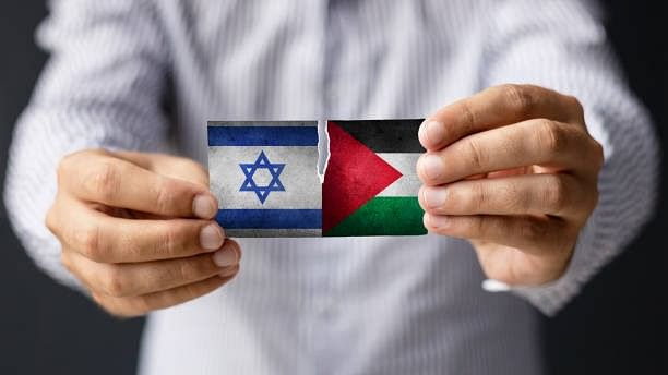 <div class="paragraphs"><p>Close-up of man holding Israeli and Palestine flag.&nbsp;</p></div>