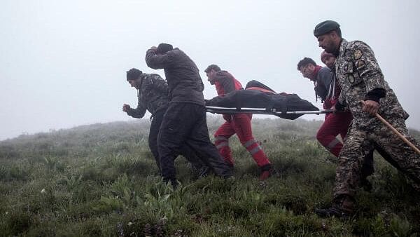 <div class="paragraphs"><p>Rescue team carry a body following a crash of a helicopter carrying Iran's President Ebrahim Raisi, in Varzaqan, East Azerbaijan Province, Iran.</p></div>