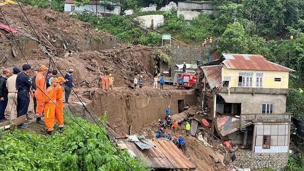 <div class="paragraphs"><p>Members of rescue teams look for survivors amidst the debris next to a stone quarry that collapsed following torrential rains, on outskirts of Aizawl.</p></div>