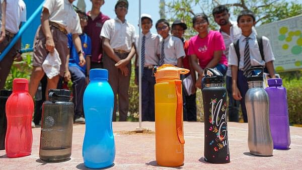 <div class="paragraphs"><p> Students look at their water bottles on 'zero shadow day' in Bengaluru.</p></div>