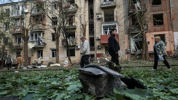 <div class="paragraphs"><p>Local residents walk near an apartment building damaged by a Russian air strike, amid Russia's attack on Ukraine, in Kharkiv, Ukraine.</p></div>