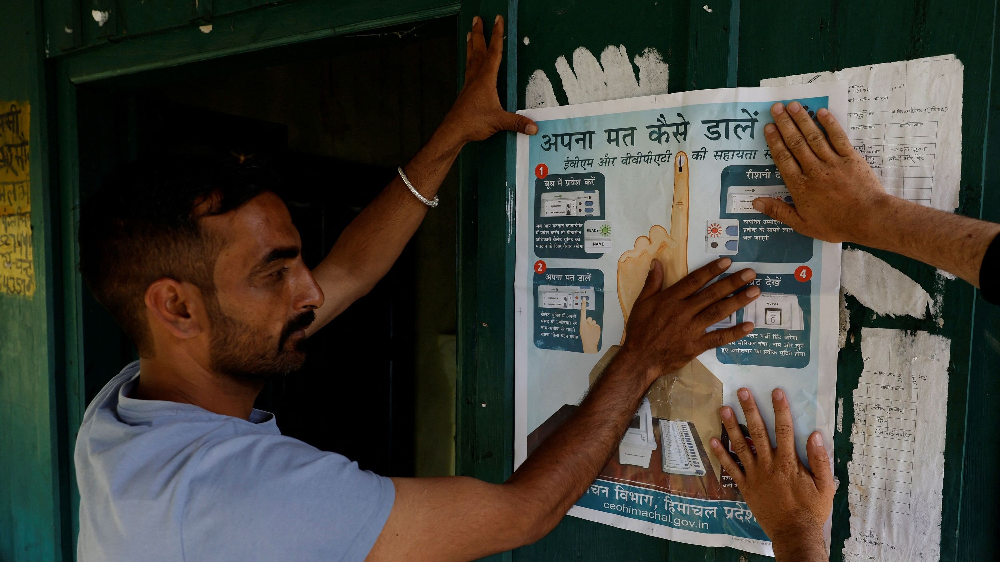 <div class="paragraphs"><p>Polling officials put up an election poster outside a remote polling station in Almi, ahead of the seventh and final phase of the elections, in  Himachal Pradesh.</p></div>