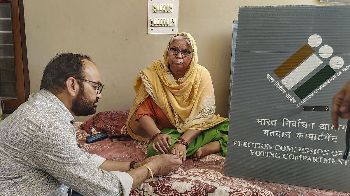 <div class="paragraphs"><p>A polling official assists a senior citizen to cast her vote exercising the 'vote-from-home' facility for Lok Sabha elections, in Gurugram, Thursday, May 16, 2024.</p></div>