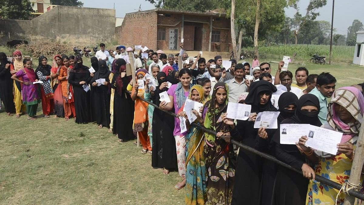 <div class="paragraphs"><p>Burqa-clad women, along with other voters, show their voter identity cards as they wait to cast their votes. (Representative image)</p></div>