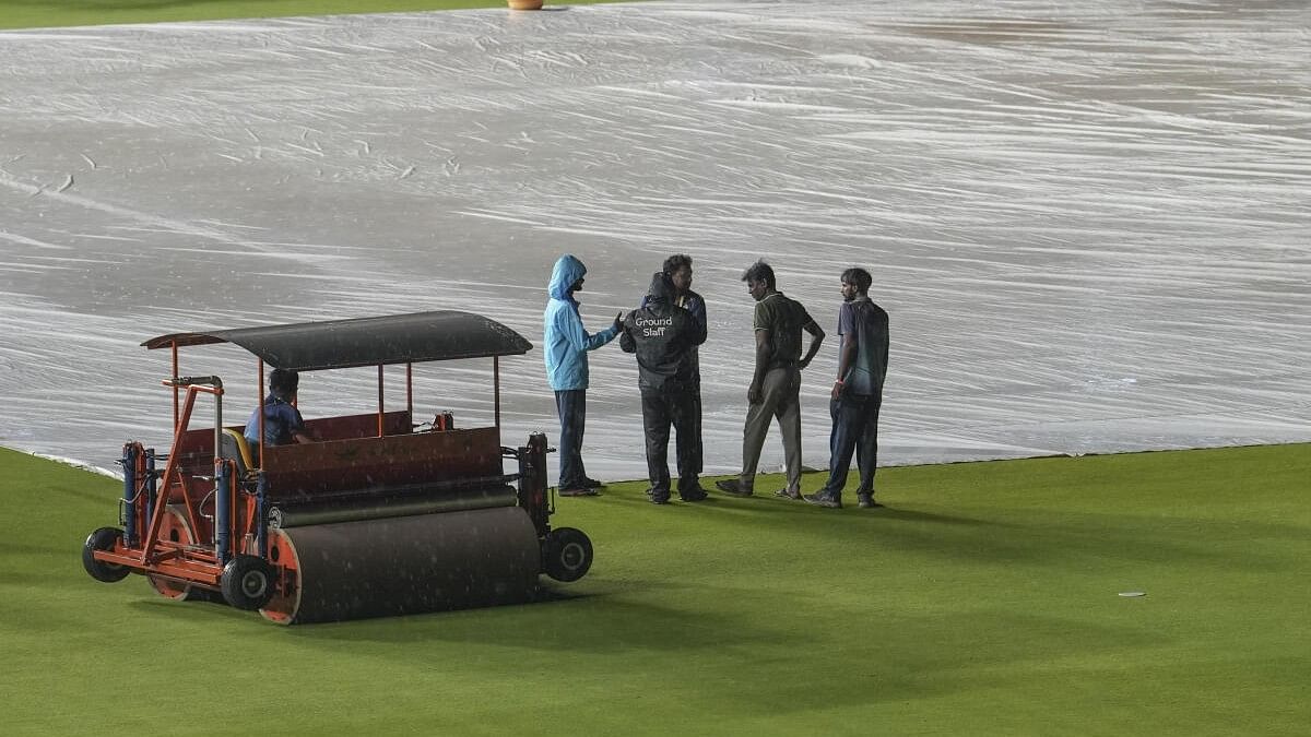 <div class="paragraphs"><p>Groundsmen stand near covered pitch as they wait for the start of the Indian Premier League (IPL) 2024 cricket match between Gujarat Titans and Kolkata Knight Riders, at Narendra Modi Stadium in Ahmedabad.</p></div>