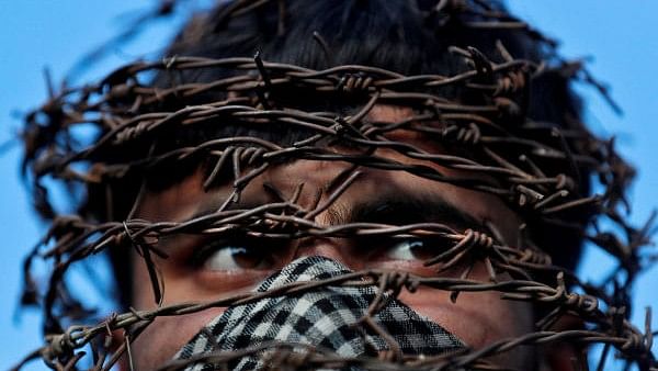 <div class="paragraphs"><p>A masked Kashmiri man with his head covered with barbed wire attends a protest after Friday prayers during restrictions following the scrapping of the special constitutional status for Kashmir by the Indian government, in Srinagar, October 11, 2019.</p></div>