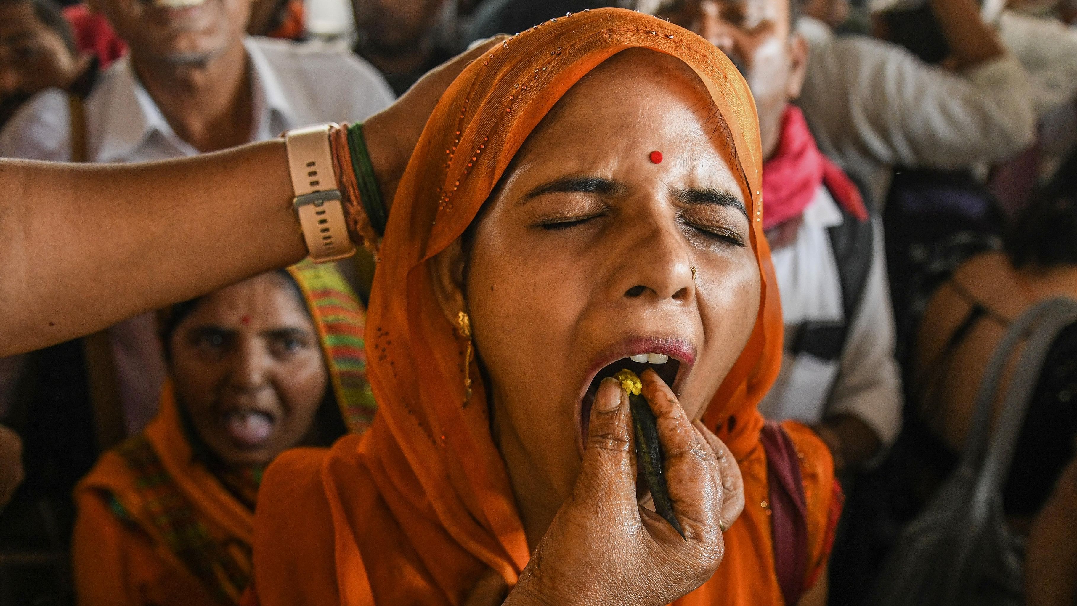 <div class="paragraphs"><p>A woman receives traditional fish 'prasadam' from a Bathini family member to get relief from respiratory problems, at the Nampally Exhibition ground in Hyderabad, on June 9, 2023</p></div>