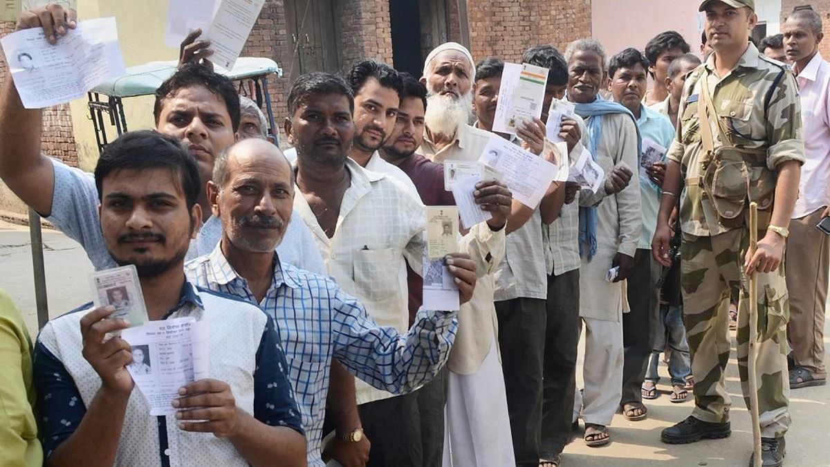 <div class="paragraphs"><p>Representative Image: </p><p>Voters show their voter identity cards as they wait in a queue to cast their votes near a polling booth.</p></div>