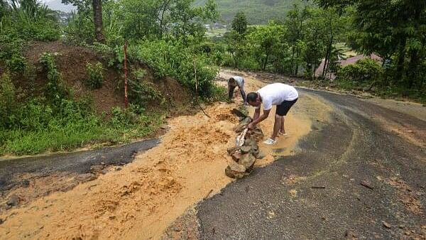 <div class="paragraphs"><p>Residents divert water from a road during incessant rains, in Senapati district, Manipur.</p></div>