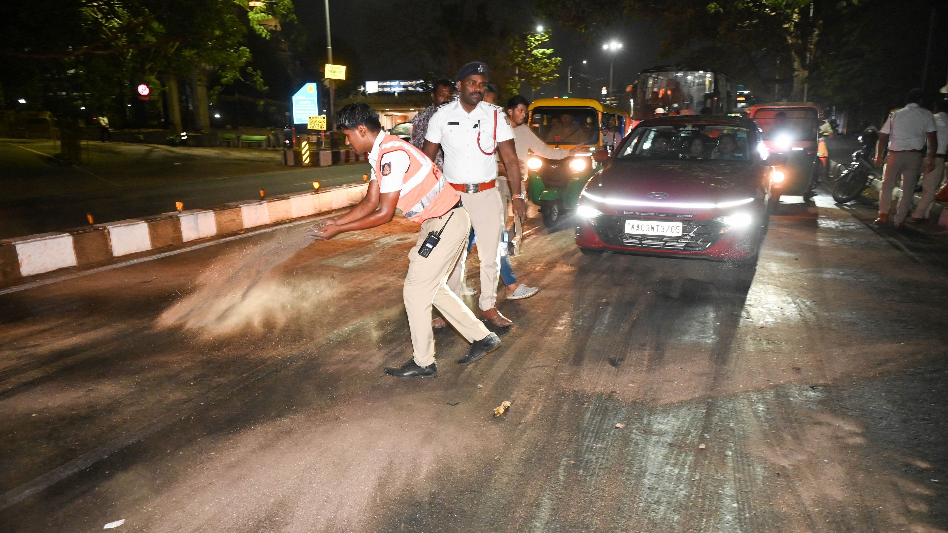 <div class="paragraphs"><p>Police throw sand in front of Vikasa Soudha to prevent motorists from slipping on wet roads on Thursday night.&nbsp;</p></div>