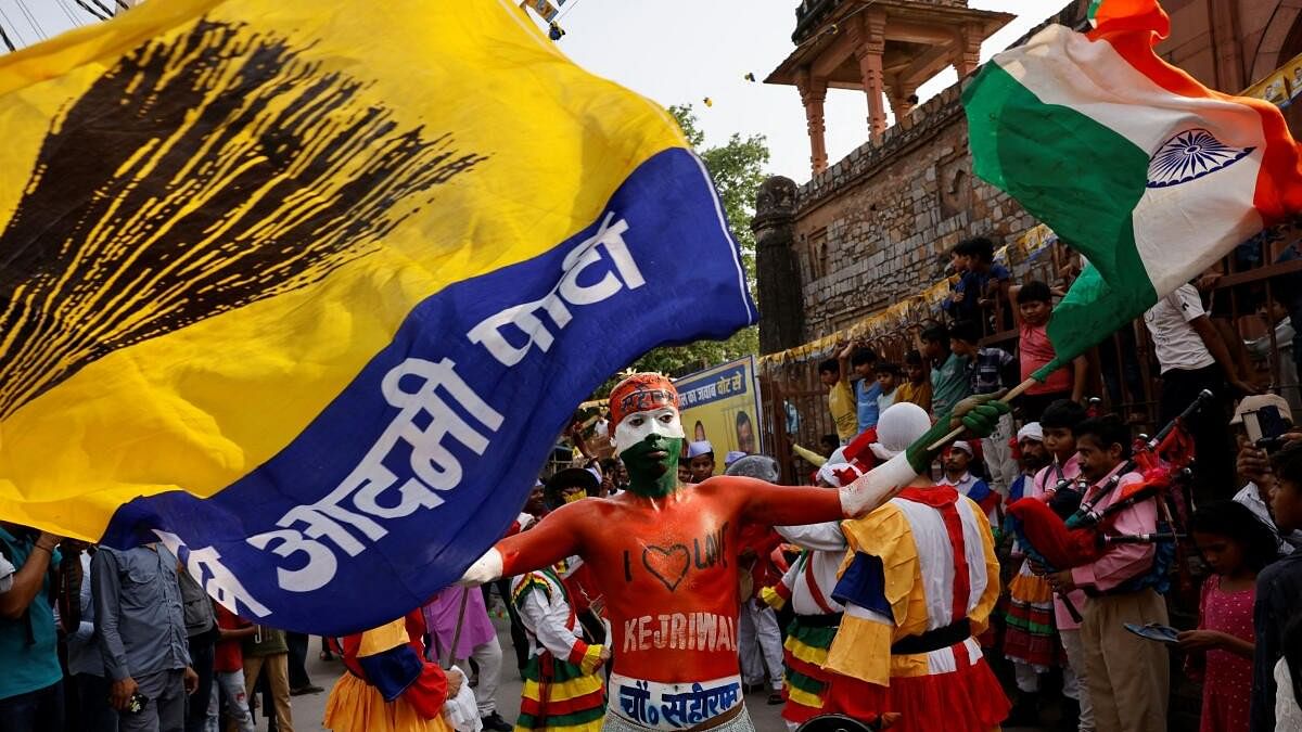 <div class="paragraphs"><p>A person with body paint waves the Indian tricolour and the flag of Aam Aadmi Party (AAP)</p></div>