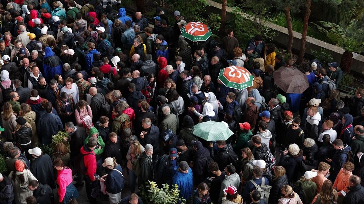 <div class="paragraphs"><p>People walk with umbrellas and raincoats during a rainy match day at the Roland Garros.</p></div>