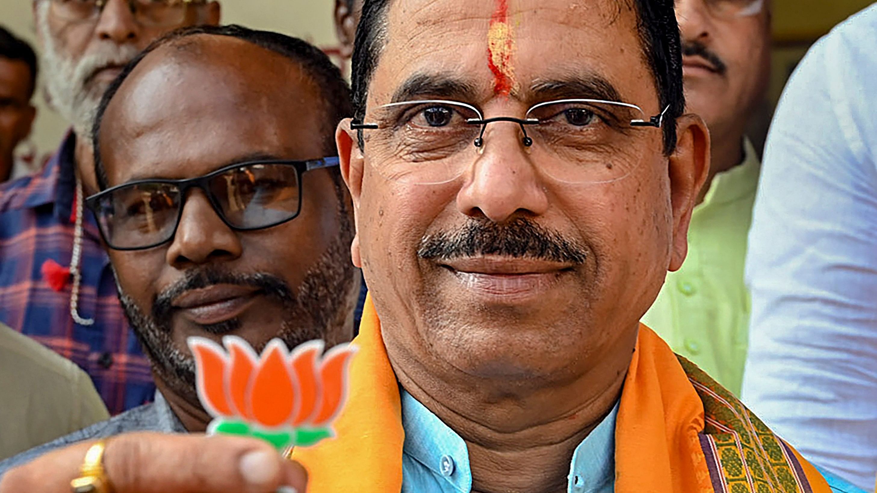 <div class="paragraphs"><p>Union Minister Pralhad Joshi shows BJP symbol 'lotus' on his arrival at the Moorusavir Math, in Hubballi, Monday, April 15, 2024.</p></div>