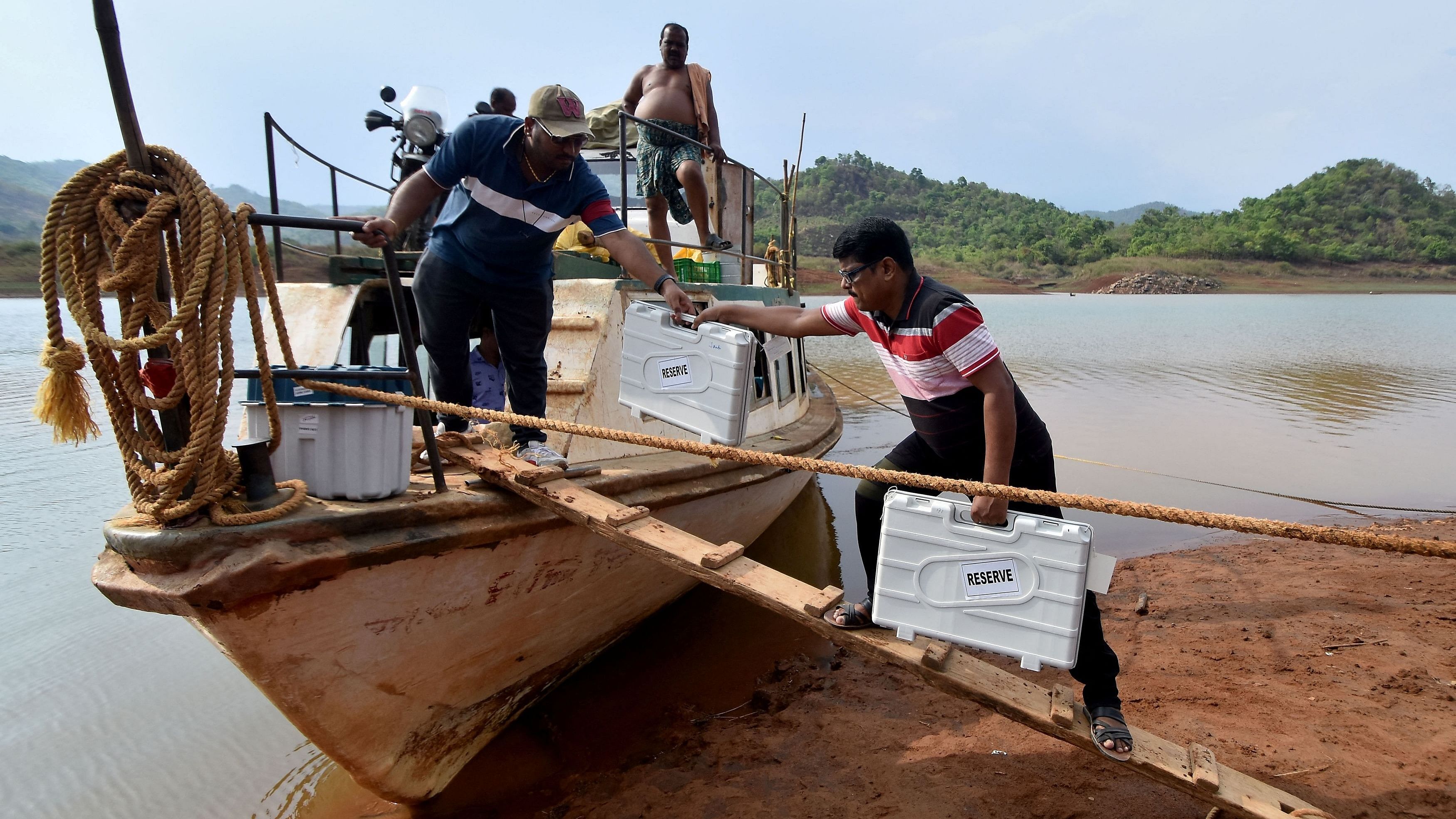 <div class="paragraphs"><p>Polling officials carrying election materials including Electronic Voting Machines (EVM) disembark a ferry upon reaching at their designated polling station in a remote area.</p></div>