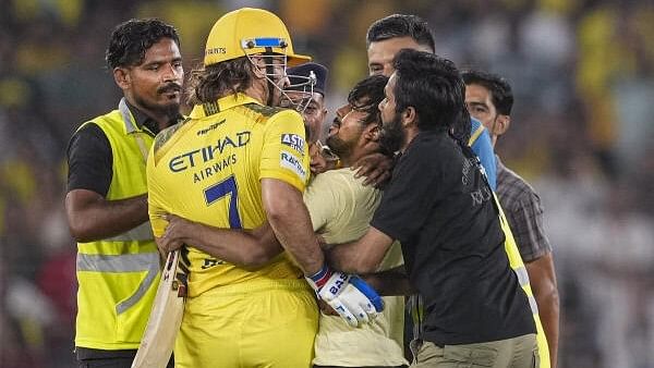 <div class="paragraphs"><p>Ground staff get hold of a pitch invader hugging Chennai Super Kings' MS Dhoni during an Indian Premier League (IPL) 2024 T20 cricket match between Gujarat Titans and Chennai Super Kings, at the Narendra Modi Stadium, in Ahmedabad, Friday, May 10, 2024.</p></div>