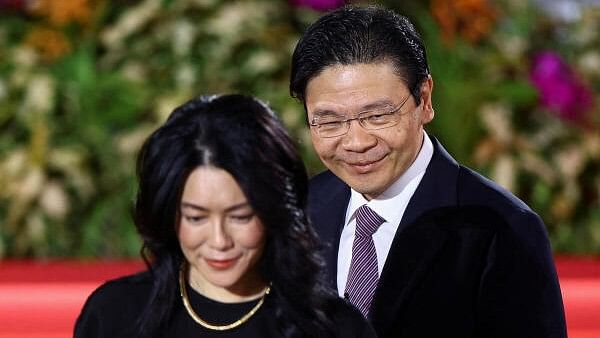 <div class="paragraphs"><p> Lawrence Wong looks on next to his wife on the day he is sworn in as Singapore's fourth Prime Minister at the Istana, in Singapore, May 15, 2024.</p></div>