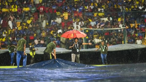 <div class="paragraphs"><p>Ground staff covers the field as rain stops play during an Indian Premier League (IPL) 2024 T20 cricket match between Royal Challengers Bengaluru and Chennai Super Kings, at the M Chinnaswamy Stadium, in Bengaluru, Saturday, May 18, 2024. </p></div>