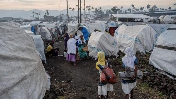 <div class="paragraphs"><p> Displaced Congolese Muslims walk past makeshift shelters at the Mugunga camp for internally displaced people, outside Goma.</p></div>