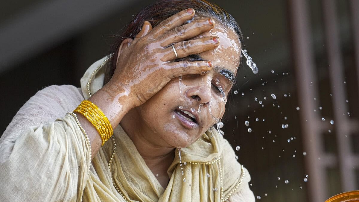 <div class="paragraphs"><p>A woman splashes water on her face on a hot summer day amid heatwave.</p></div>