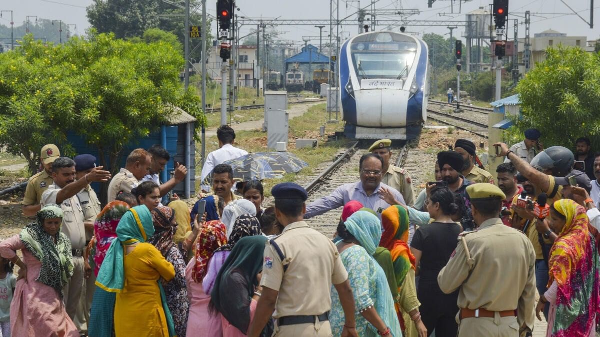 <div class="paragraphs"><p>Railway Colony residents block a railway track during a protest near Jammu railway station against water scarcity as a Vande Bharat Express train awaits passage, in Jammu.</p></div>