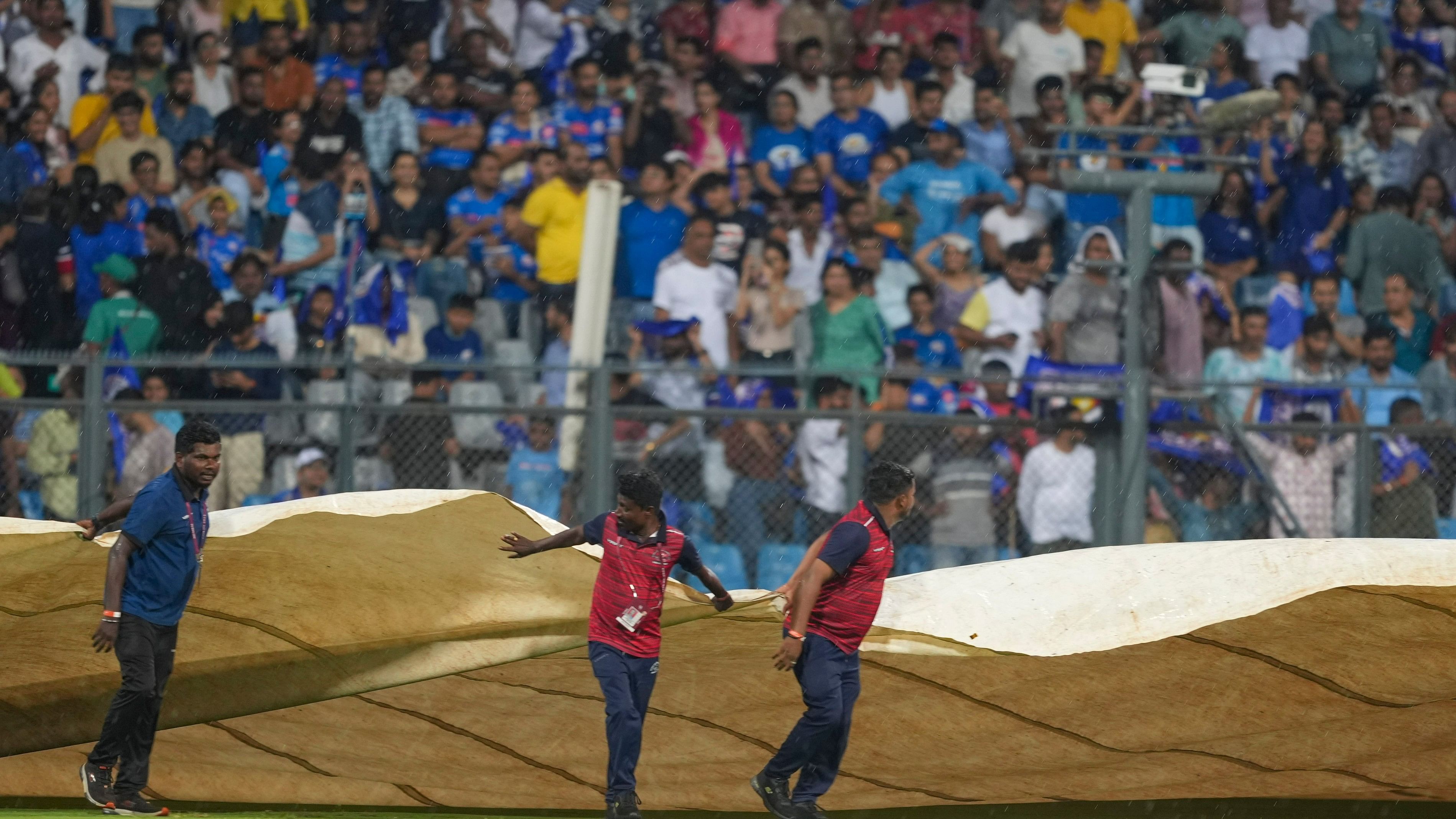 <div class="paragraphs"><p>Mumbai: Groundsmen place pitch and outfield covers as it rains during the IPL 2024 cricket match between Lucknow Super Giants and Mumbai Indians, at Wankhede Stadium in Mumbai, Friday, May 17, 2024. </p></div>