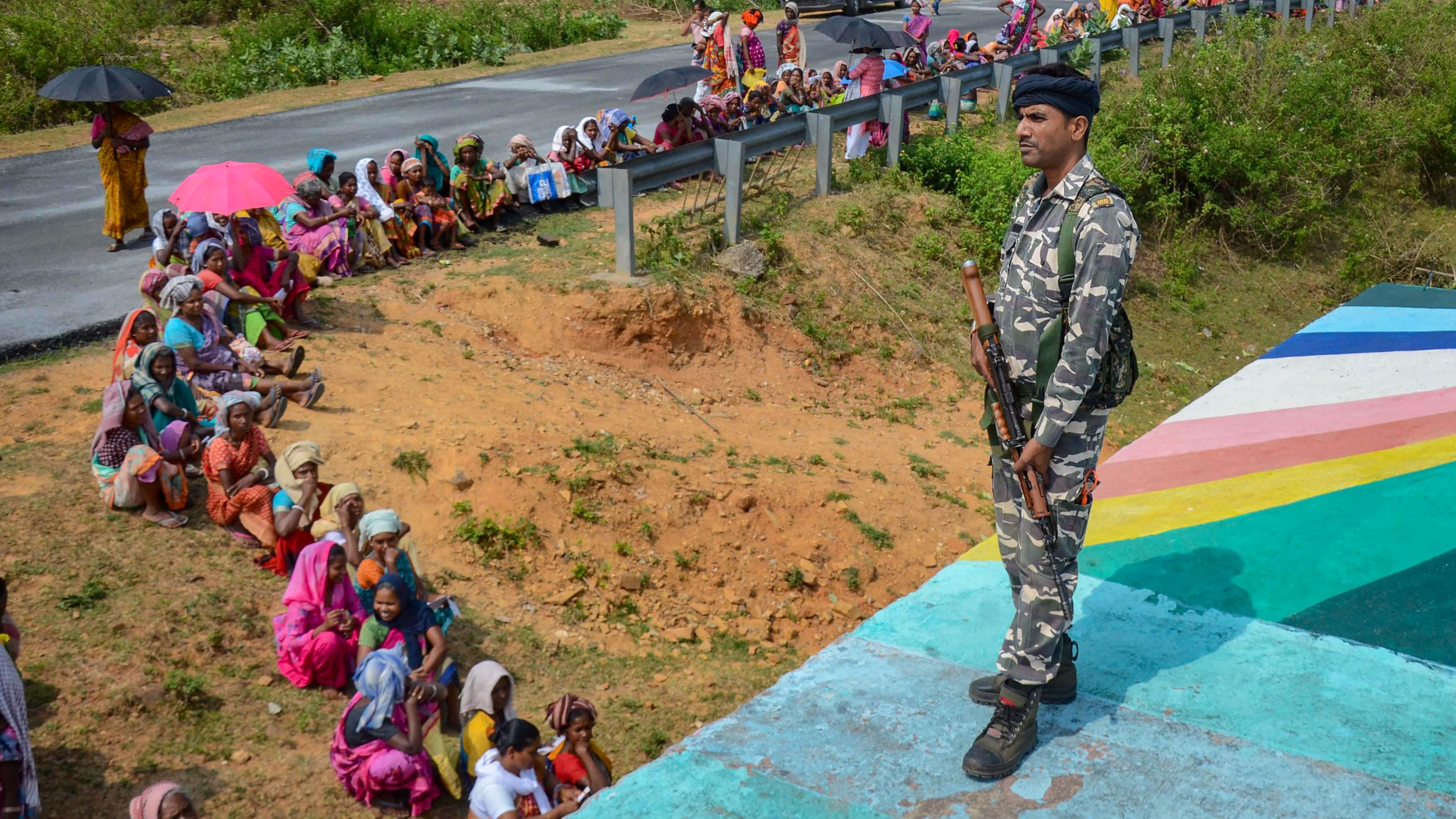 <div class="paragraphs"><p> A security personnel keeps vigil as people wait to cast their vote during the fourth phase of Lok Sabha elections, in Khunti district, Monday, May 13, 2024.</p></div>