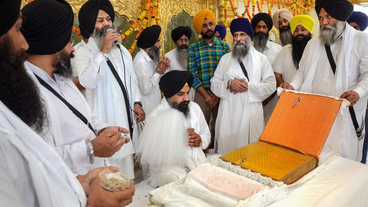 <div class="paragraphs"><p>File photo of Sikh priests displaying a copy of Guru Granth Sahib that is said to have been hit by a bullet during Operation Blue Star of 1984, on the 39th anniversary of the operation, in Amritsar.&nbsp;</p></div>