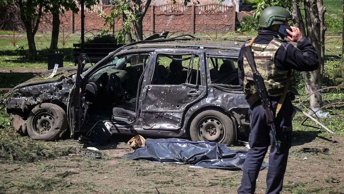 <div class="paragraphs"><p>A police officer stands near a destroyed car at a site of a Russian missile strike in Kharkiv region in Ukraine on May 1.</p></div>