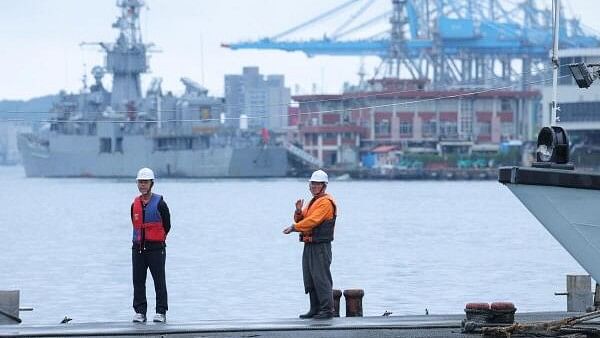 <div class="paragraphs"><p>Two staff members look on as navy ships park at the port, as China announces new military drills around Taiwan, in Keelung, Taiwan May 23, 2024.</p></div>