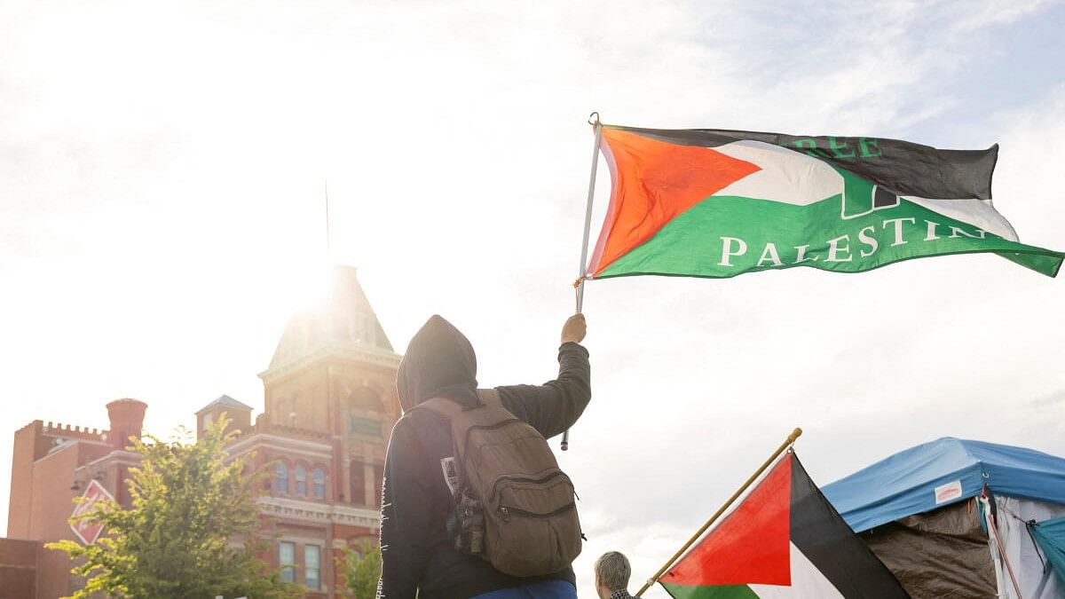 <div class="paragraphs"><p>A protester raises the Palestinian flag at an encampment in support of the Palestinians, amid the ongoing conflict between Israel and the Palestinian Islamist group Hamas, at the Auraria Campus in Denver, Colorado</p></div>