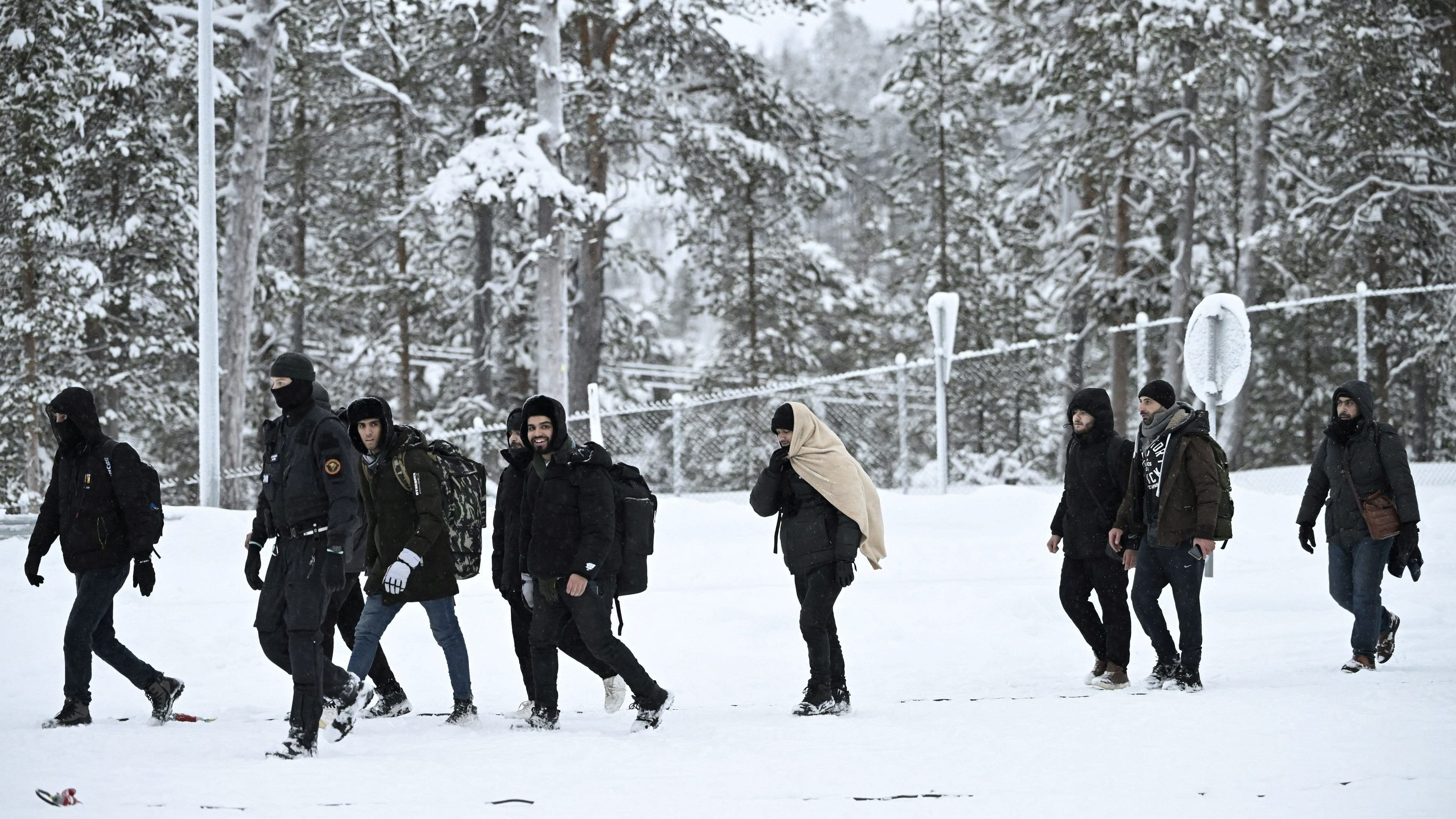 <div class="paragraphs"><p>Finnish Border Guards escort migrants arriving  international border crossing station in Finland.</p></div>