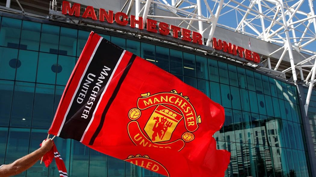 <div class="paragraphs"><p>Manchester United fans wave a flag outside the stadium before a match.</p></div>