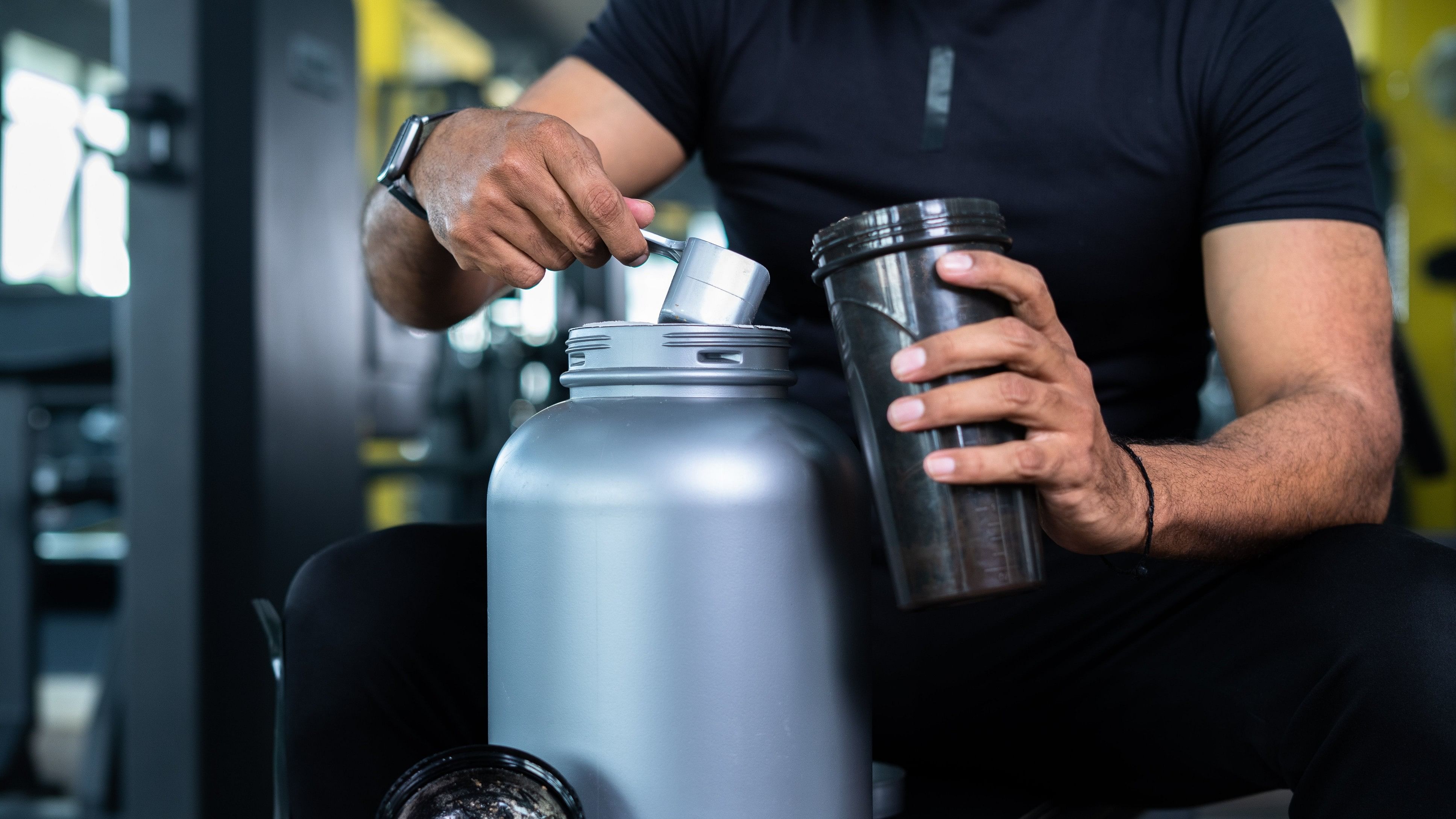 <div class="paragraphs"><p>Close up shot of bodybuilder hands taking protein powder and mixing with water on bottle by shaking at gym - concept of muscular gain, nutritional supplement and wellness.</p></div>