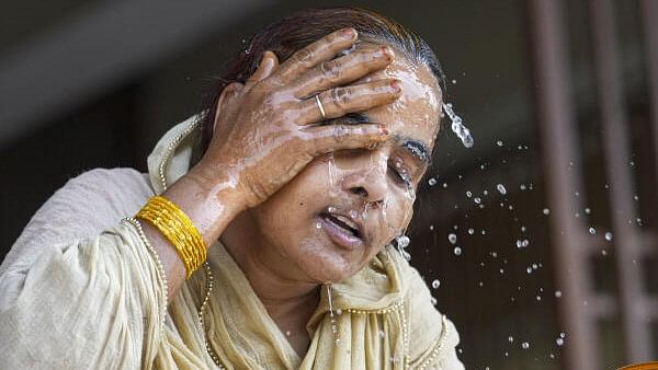 <div class="paragraphs"><p>A woman splashes water on her face on a hot summer day amid heatwave, in New Delhi, Wednesday, May 29, 2024. Heatwave to severe heatwave conditions will prevail over most parts of Delhi, the India Meteorological Department (IMD) said in its weather forecast warnings.</p></div>