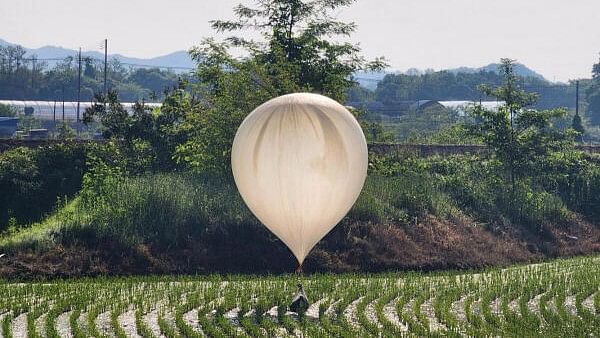 <div class="paragraphs"><p>A balloon believed to have been sent by North Korea, carrying various objects including what appeared to be trash and excrement, is seen over a rice field at Cheorwon.</p></div>