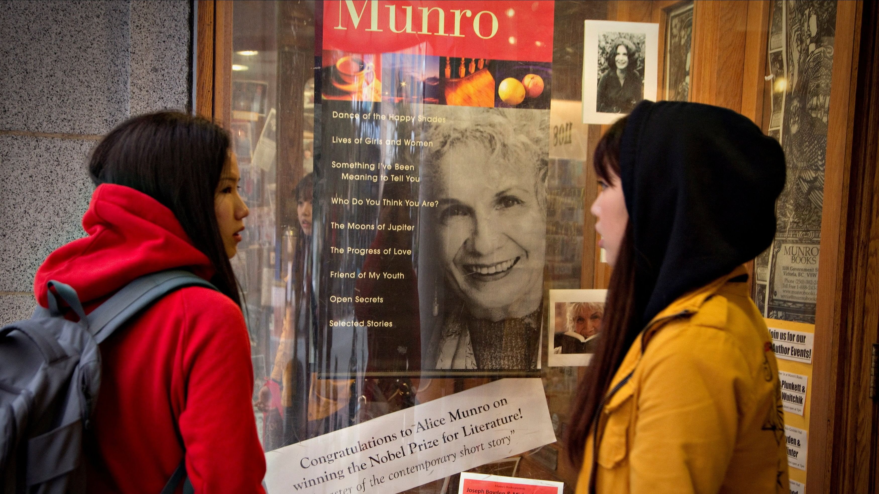 <div class="paragraphs"><p>Customers look at a window display on Canadian author Alice Munro </p></div>