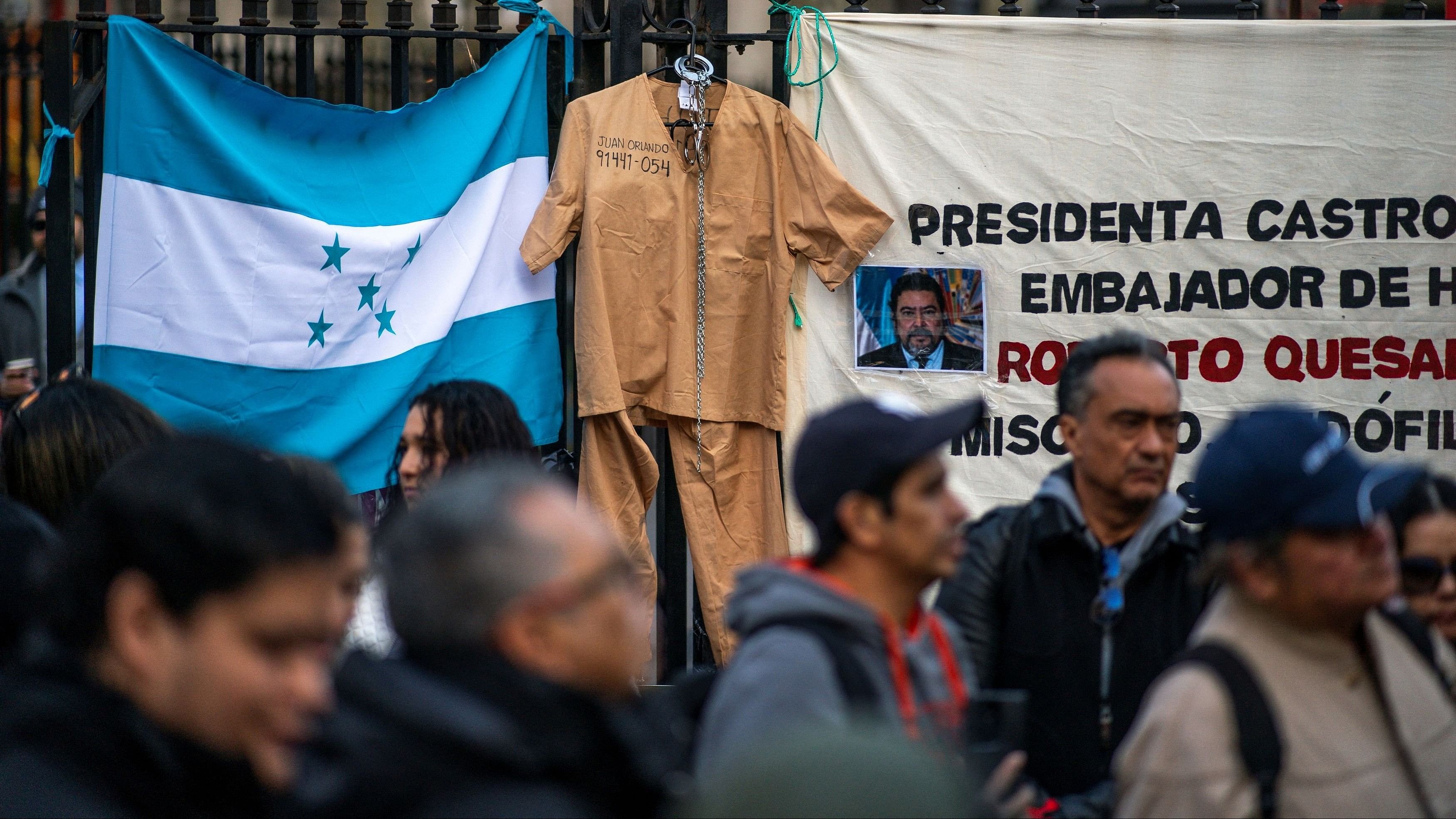 <div class="paragraphs"><p>Prisoner clothes hang on a fence while people react to the verdict of Former Honduras President Juan Orlando Hernandez trial on US drug trafficking charges outside federal court in the Manhattan borough of New York City, US, March 8, 2024.</p></div>