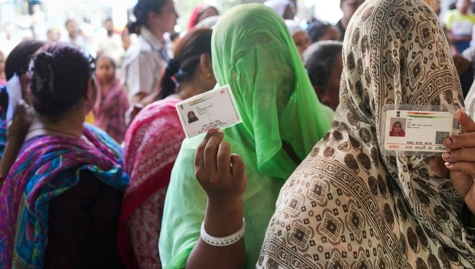 <div class="paragraphs"><p>Representative image: Women voters show their identity cards as they wait in a queue to cast their votes at a polling station.</p></div>