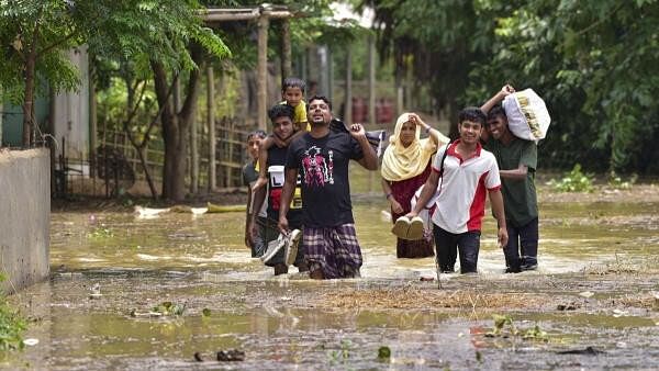 <div class="paragraphs"><p>Villagers wade through a flooded area following rains.</p></div>