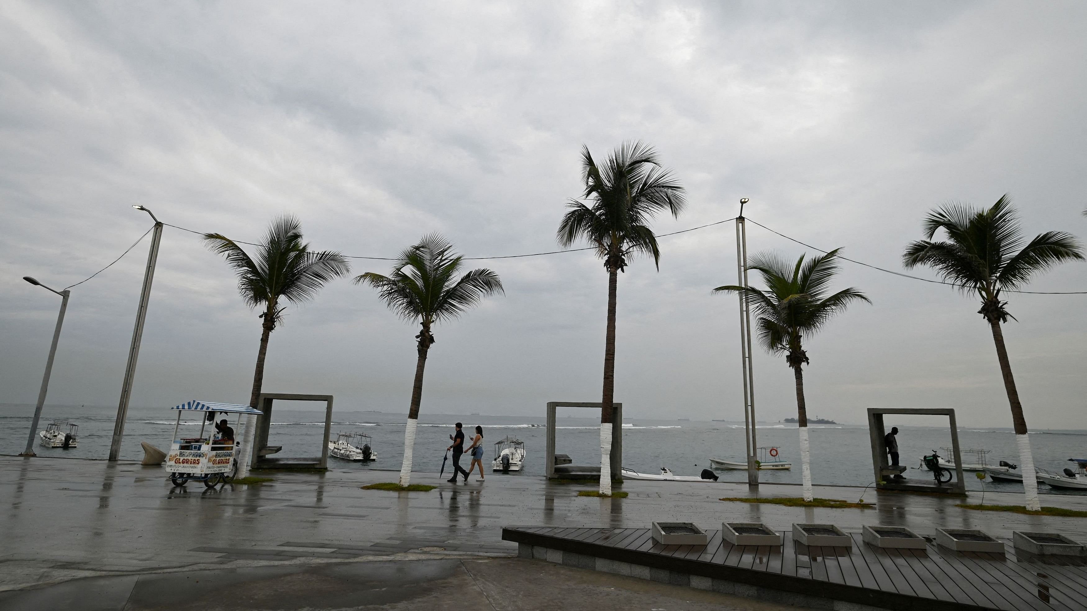 <div class="paragraphs"><p>People walk on a pier as dark clouds caused by tropical storm Alberto are seen on the horizon, in Veracruz, Mexico on June 19, 2024. </p></div>