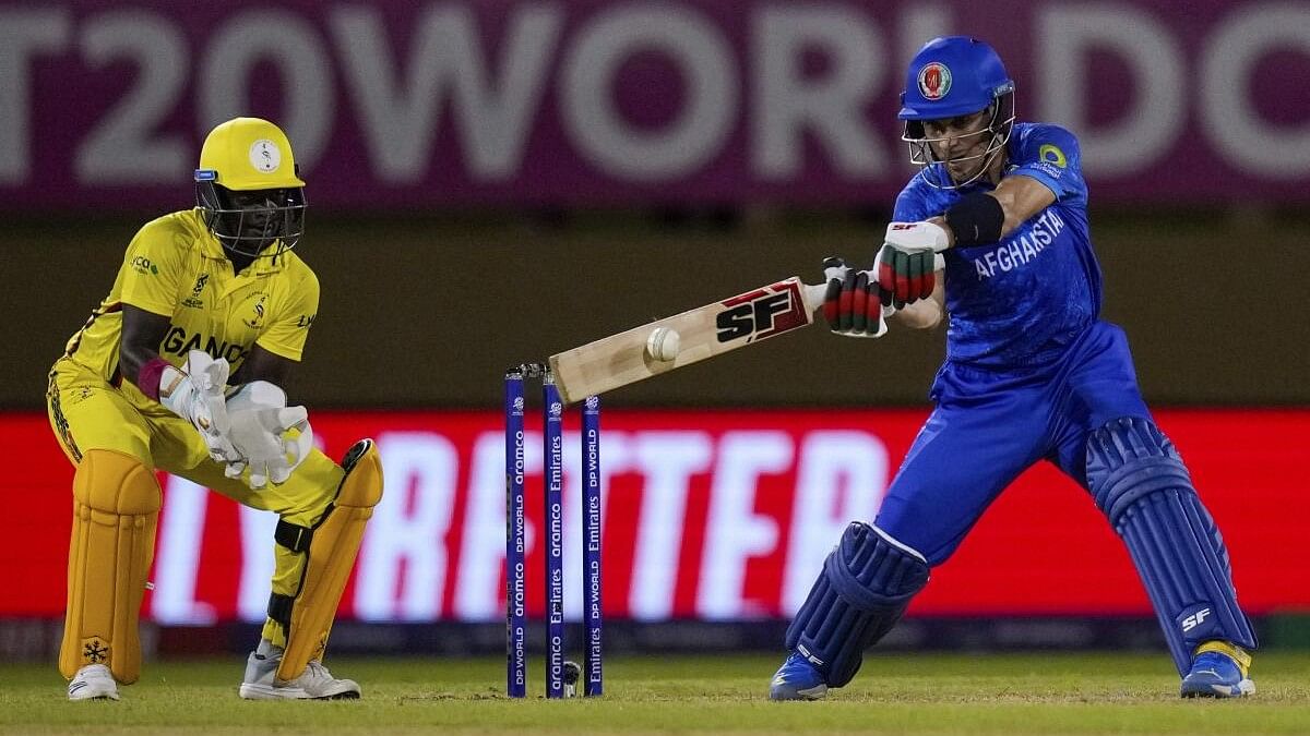 <div class="paragraphs"><p>Afghanistan's Rahmanullah Gurbaz, right, plays a shot as Uganda's wicket keeper Simon Ssesazi looks on during an ICC Men's T20 World Cup cricket match at Guyana National Stadium in Providence, Guyana, Monday, June 3, 2024.</p></div>