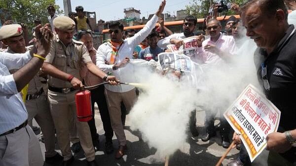 <div class="paragraphs"><p>Police personnel extinguish a fire during protest by the BJP against the Delhi Jal Board over the ongoing Delhi water crisis, in New Delhi, Sunday on June 16, 2024.</p></div>