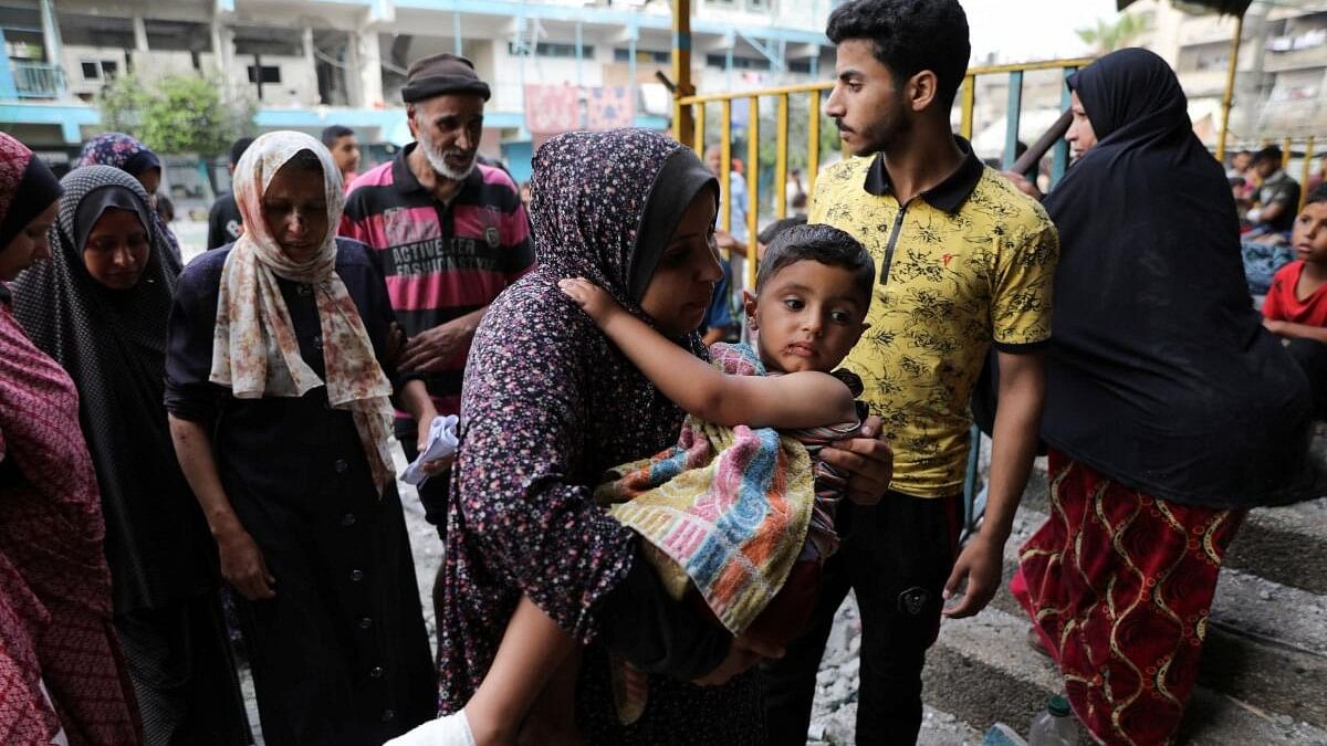 <div class="paragraphs"><p>A woman carries a child at the site of an Israeli strike on a UNRWA school sheltering displaced people, amid the Israel-Hamas conflict. (Representative image)</p></div>