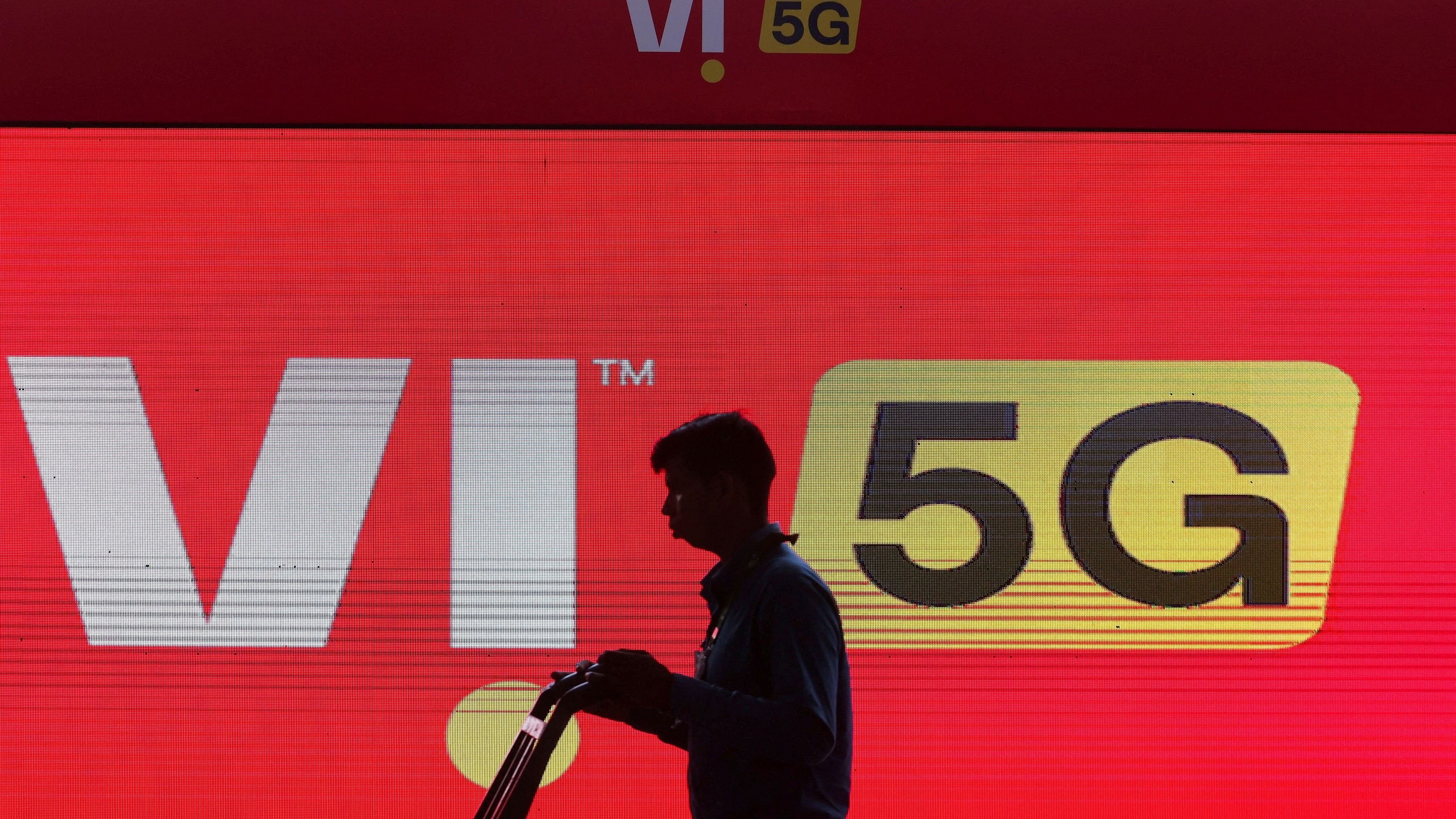 <div class="paragraphs"><p>A man walks across the LED display board showing the logo of Vodafone-Idea.</p></div>